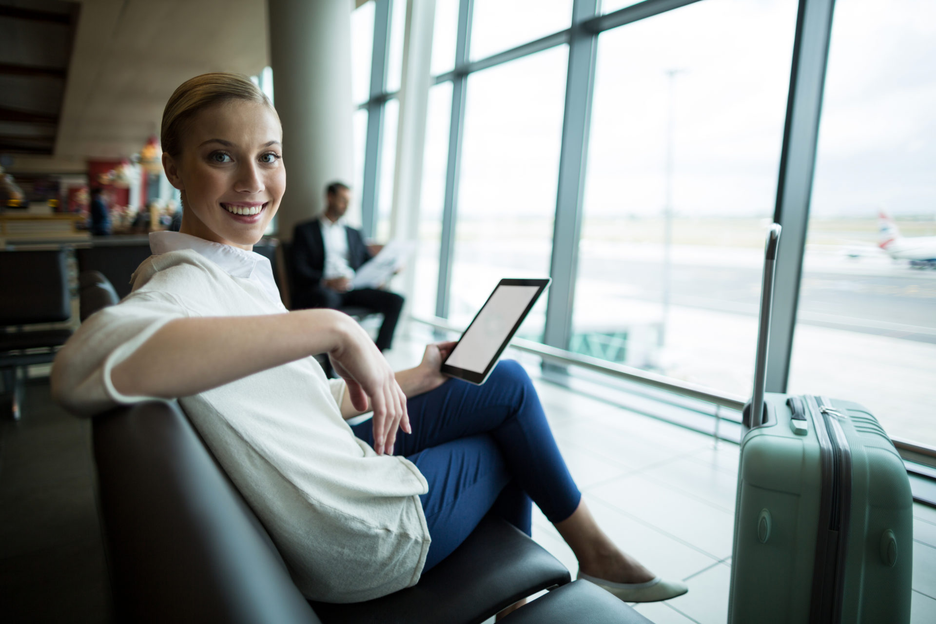 portrait-female-commuter-with-digital-tablet-sitting-waiting-area-scaled